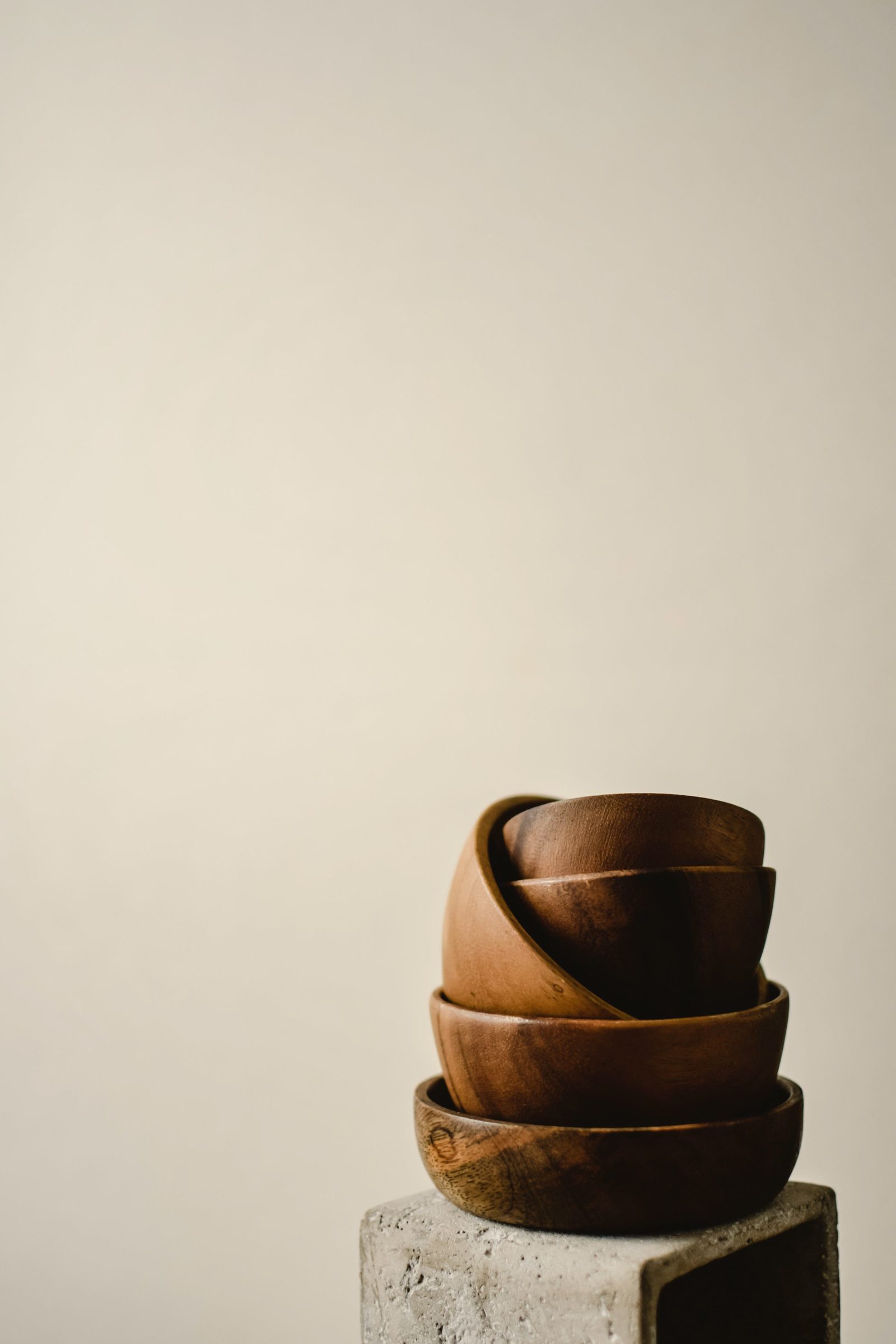 A stack of wooden bowls on a concrete plinth