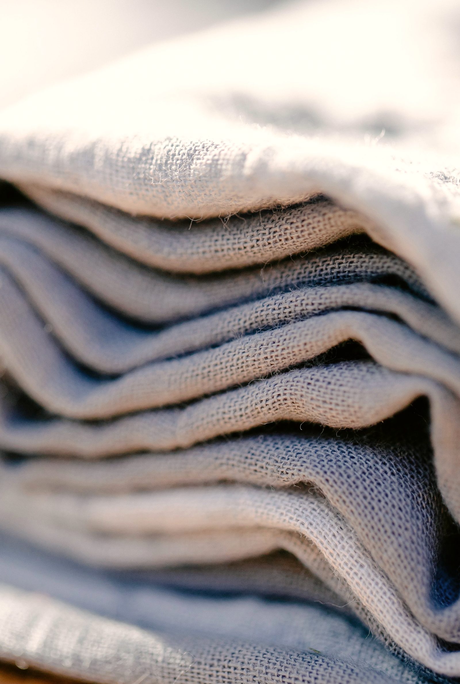 Folded layers of linen textile stacked in bright sunlight